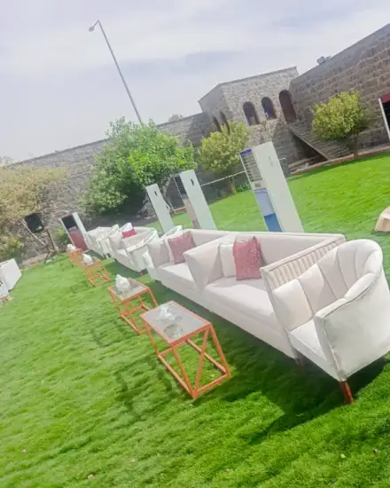 مجلس كنب: كنب وطاولات صغيرة في جلسة جاهزة.