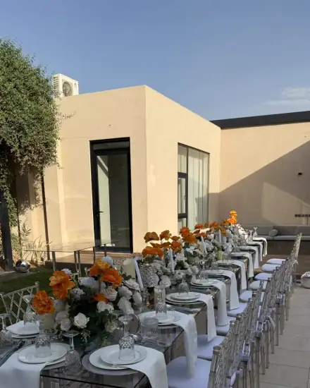 طاولة طويلة للضيوف: طاولة طويلة مجهزة بالأطباق والتنسيق.
