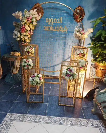 تنسيق وكوشة: ورد وأقواس وخلفية مجهزة للمناسبة.