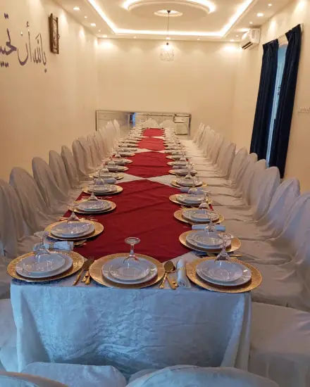 طاولة طويلة للضيوف: طاولة طويلة مجهزة بالأطباق والتنسيق.