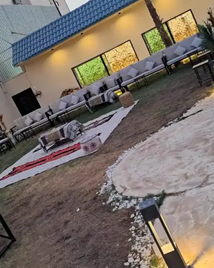 جلسة حديقة بشكل U: كنب خارجي حول مساحة عشب مفتوحة.