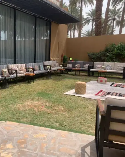 جلسة خارجية في حديقة: كنب وطاولات في حديقة منزل.