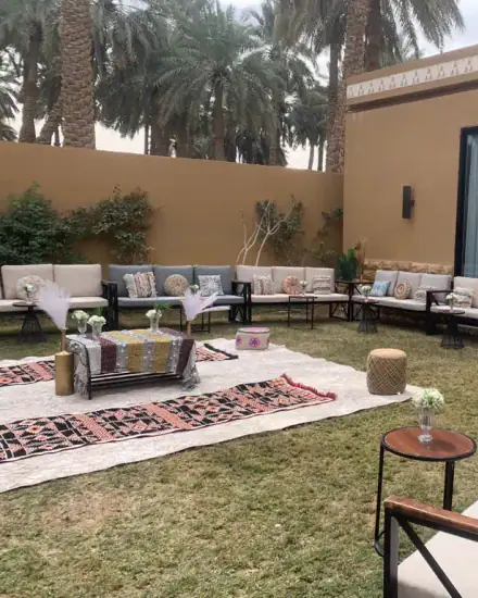 جلسة حديقة بشكل U: كنب خارجي حول مساحة عشب مفتوحة.