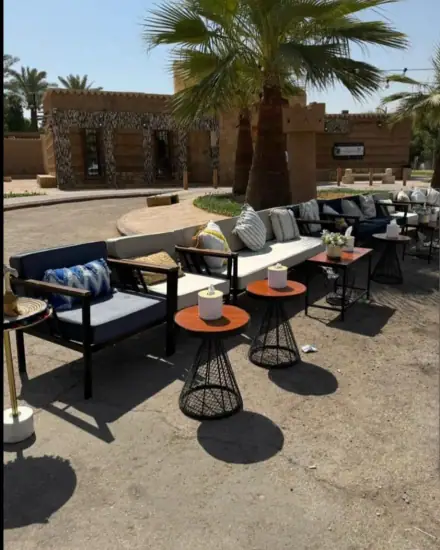 مجلس كنب: كنب وطاولات صغيرة في جلسة جاهزة.