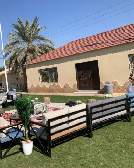 جلسة حديقة بشكل U: كنب خارجي حول مساحة عشب مفتوحة.