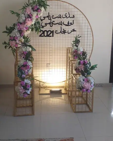 تنسيق وكوشة: ورد وأقواس وخلفية مجهزة للمناسبة.