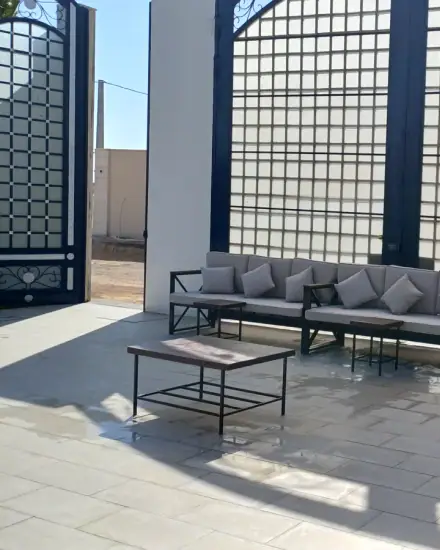 مجلس كنب: كنب وطاولات صغيرة في جلسة جاهزة.